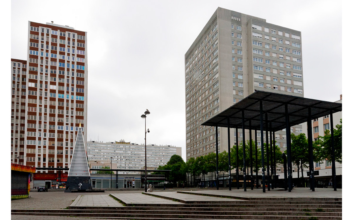 Le projet pour lequel nous j'ai été solicitée consiste en la participation à la rénovation des paliers de l’immeuble situé 15 rue Henri Ribière à Paris19ème (à l’exception d’un niveau qui a été rénové récemment suite à un incendie) par l'agence d'architecture et de design d'intérieur PETERMAAN.  Situé devant la Place des Fêtes, l’immeuble construit en 1974 par l'architecte Marc Leboucher a fait partie du programme d’urbanisation de la place, qui l’a transformée de façon radicale avec la construction de 7 tours dont 2 IGH de 35 niveaux, 5 autres de 18 niveaux et 11 édifices de plus de 12 étages. Aujourd’hui, non seulement la population de ces tours n’élève aucun lamento anti-béton, mais elle a suscité sur le quartier l’avènement d’une culture multi-ethnique, néo-bellevilloise et populaire, d’une nouvelle manière.  L’immeuble du 15 rue Henri Ribière haut de 18 étages (non qualifié IGH) comprend 174 logements, du studio au 5 pièces. 3 ascenseurs desservent tous les étages identiques, avec 10 appartements par étage, à l’exception du 17ème et du 18ème qui sont des demi-étages.  J'ai produit 2 motifs en réinterprêtant les motifs de la mosaïque du hall d’entrée, qui seront ensuite imprimés à la dimension des murs des fonds de couloir sur un lé en vinyle encadré par des baguettes.